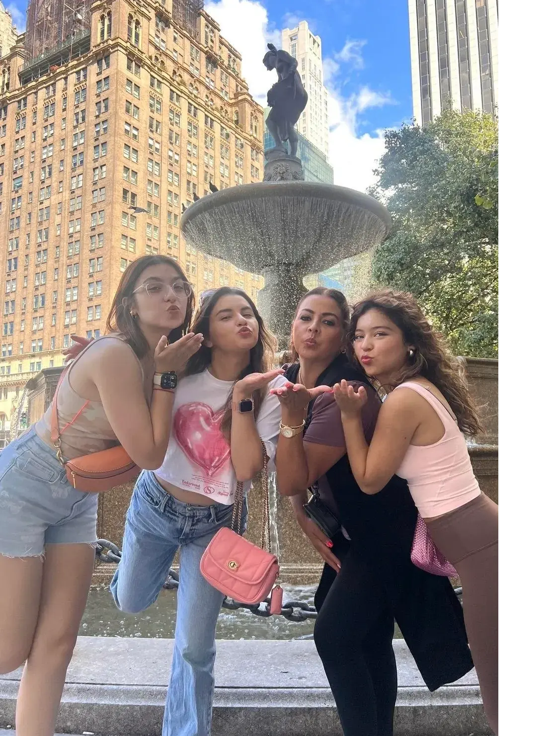 Two guests posing at the Pulitzer Fountain on a Gossip Girl Tours stop in Manhattan