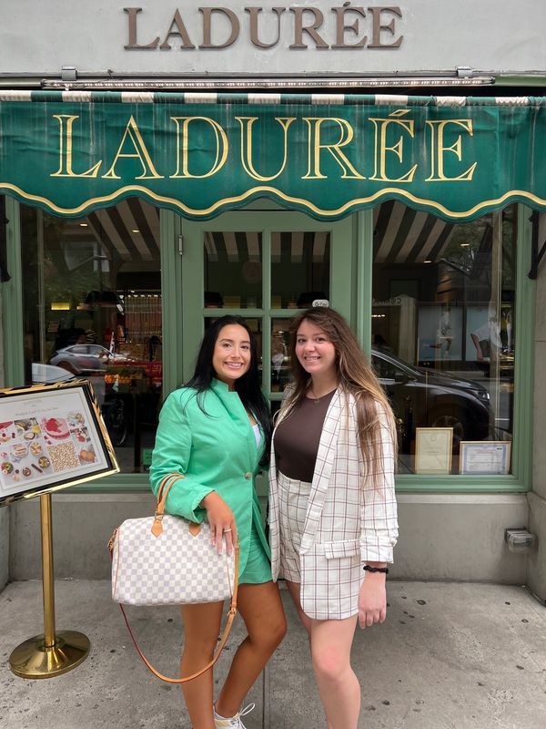 Guests with a designer bag outside the Ladurée storefront on a Gossip Girl Tours stop in Manhattan
