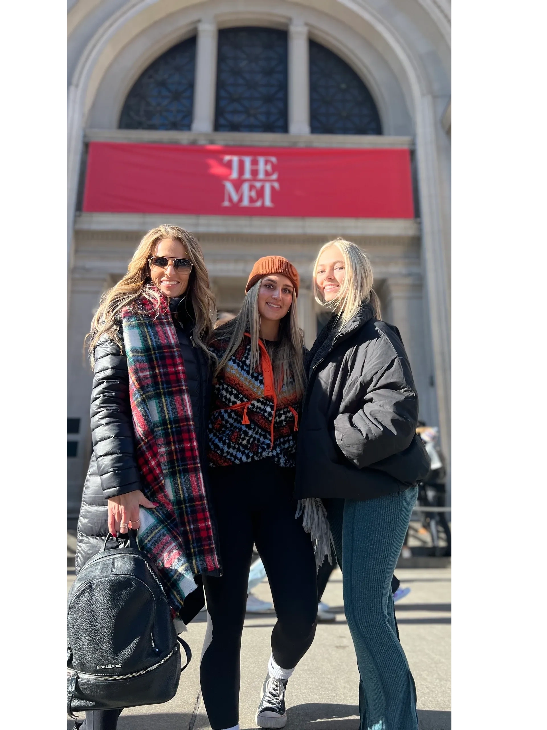 Three Gossip Girl Tours guests in front of The Met banners on Fifth Avenue