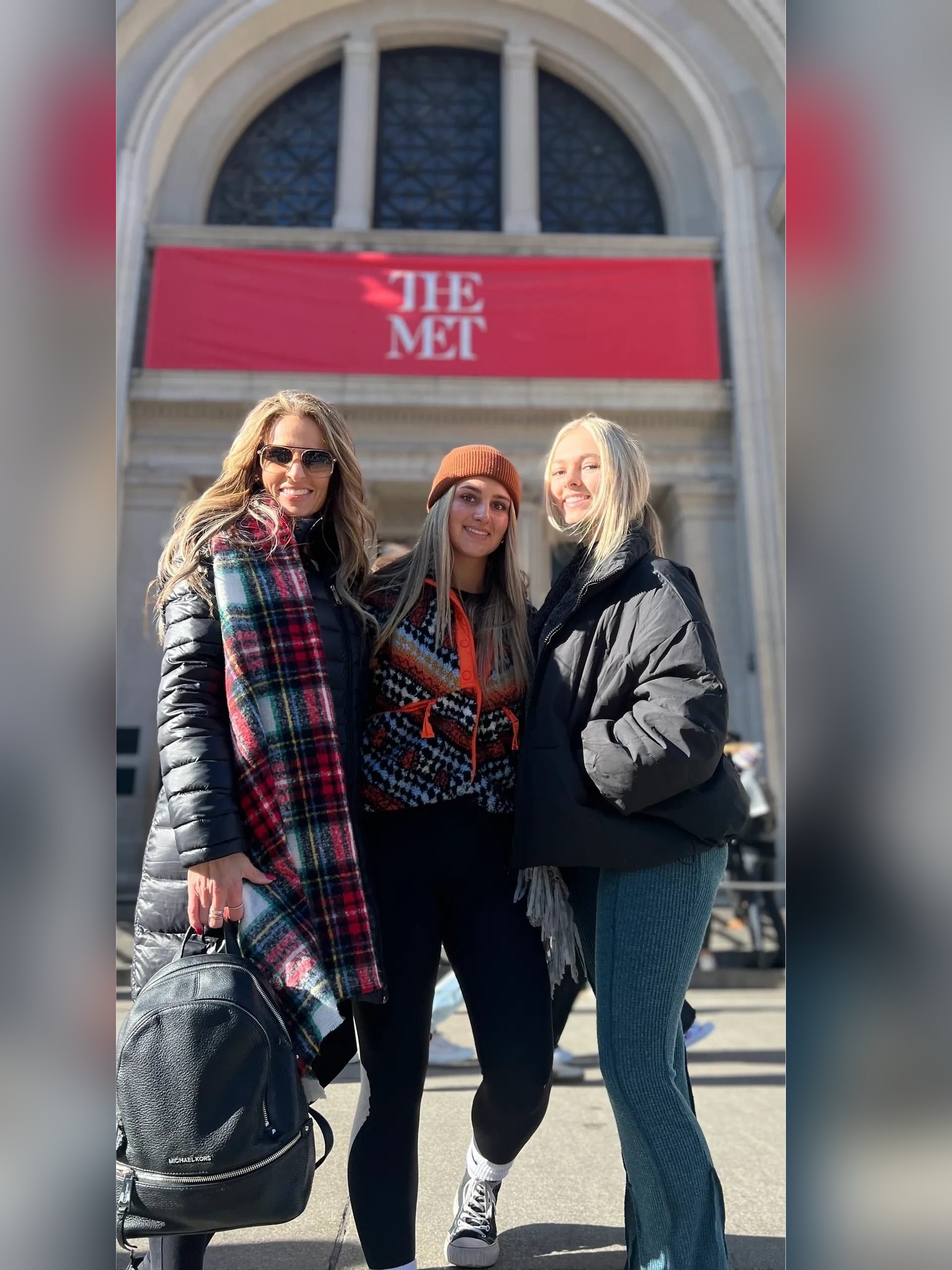 Drei Gäste der Gossip Girl Tours vor The Met-Bannern auf der Fifth Avenue in New York City