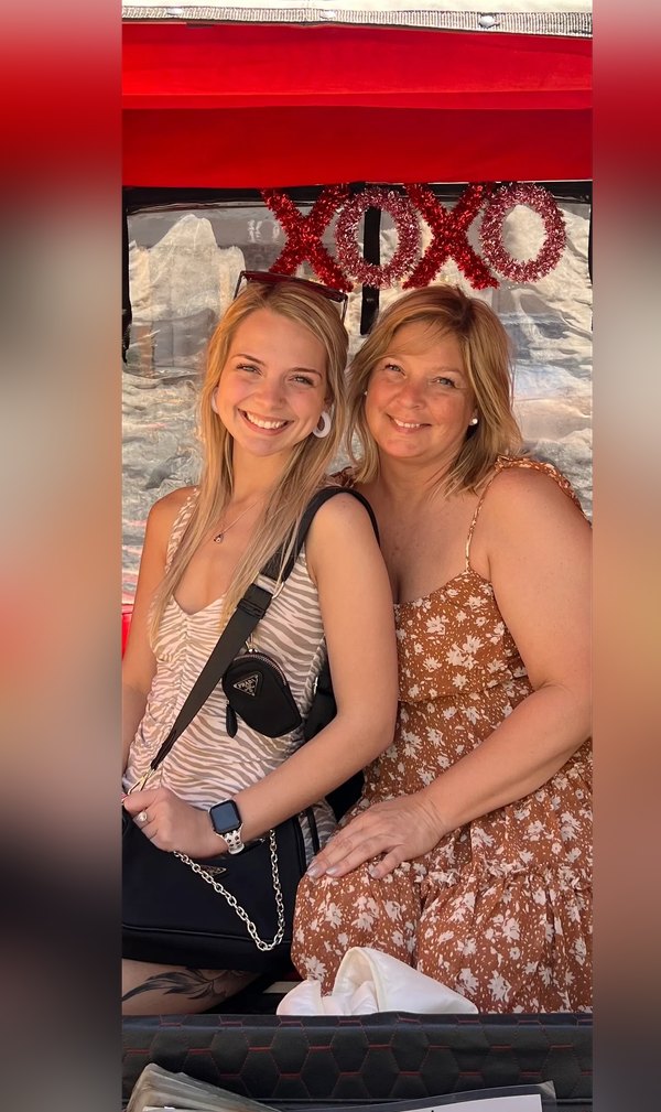 Zwei Gäste der Gossip Girl Tours in einem roten pedicab mit XOXO-Schild in New York City
